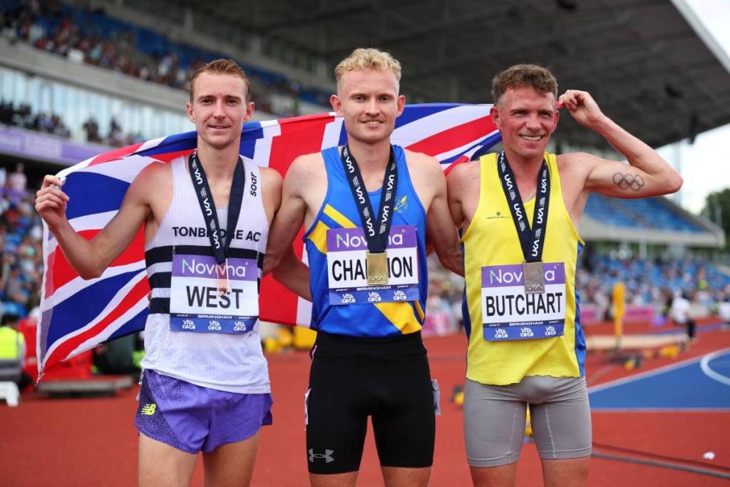 BIRMINGHAM, ENGLAND - JUNE 21: (L-R) Bronze medallist James West of Tonbridge AC, Gold medallist David Mullarkey of Leamington Cycling and Athletic, and Silver medallist Andrew Butchart of Central AC, pose for a photo as they celebrate with their nation's flag after the Men's 5000 m Final during day two of the UK Athletics Championships at Alexander Stadium on June 21, 2026 in Birmingham, England. (Photo by Ed Sykes/Getty Images)