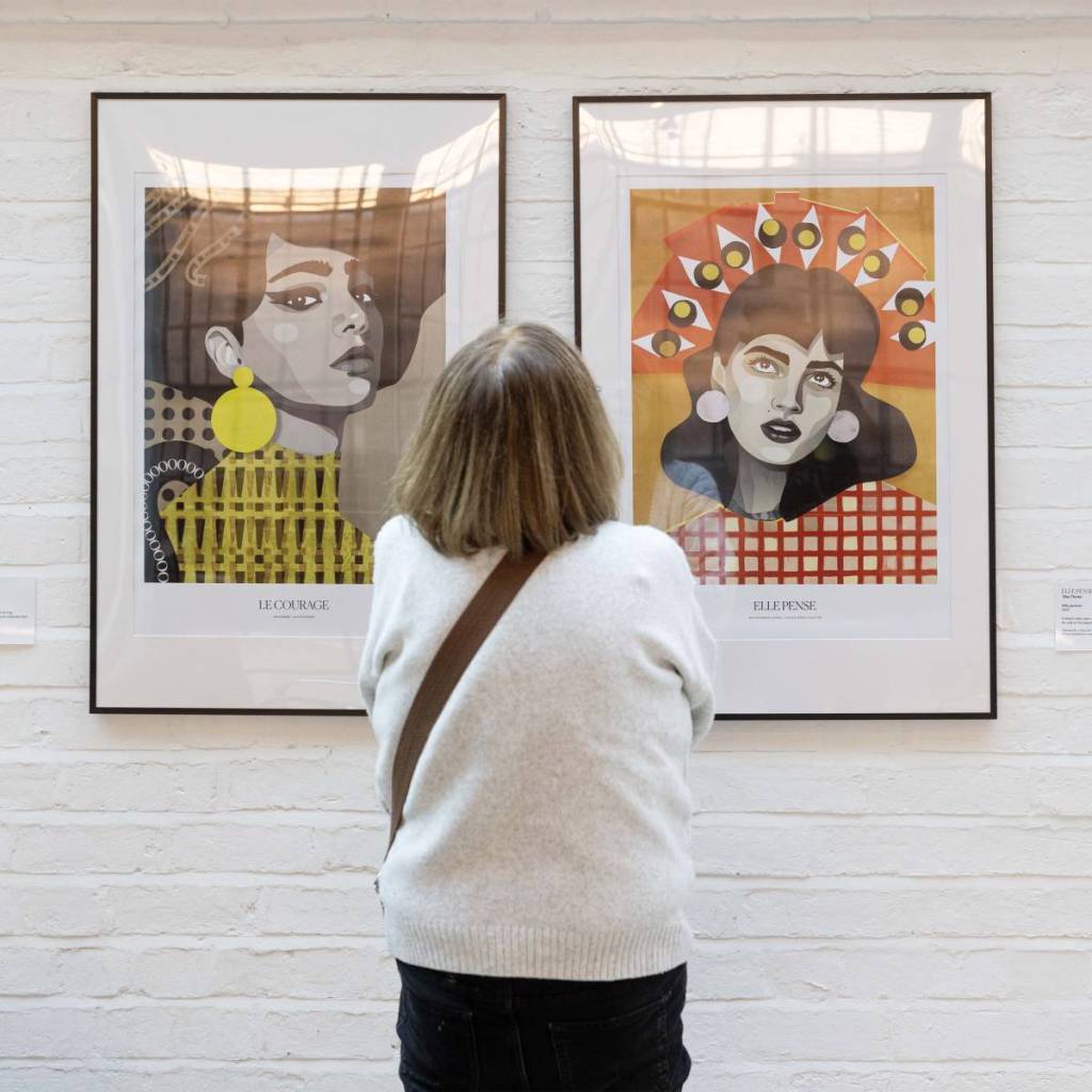 A woman looking at two artworks at Birmingham Open Studios