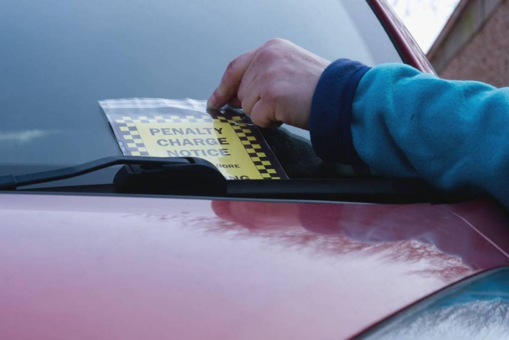 Driver finds parking ticket on windshield of car medium shot selective focus