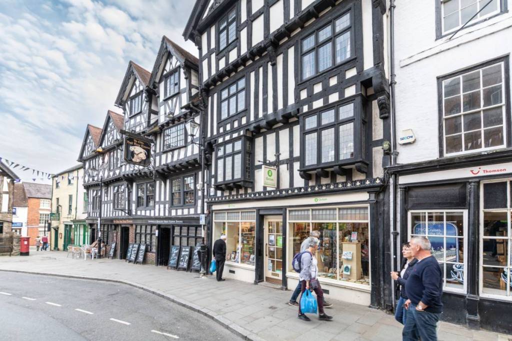 Ludlow, Shropshire, England - Sep 11 2015; Old Tudor Buildings housing Ye Olde Bull King Tavern and the Oxfam Shop in Kings Street.