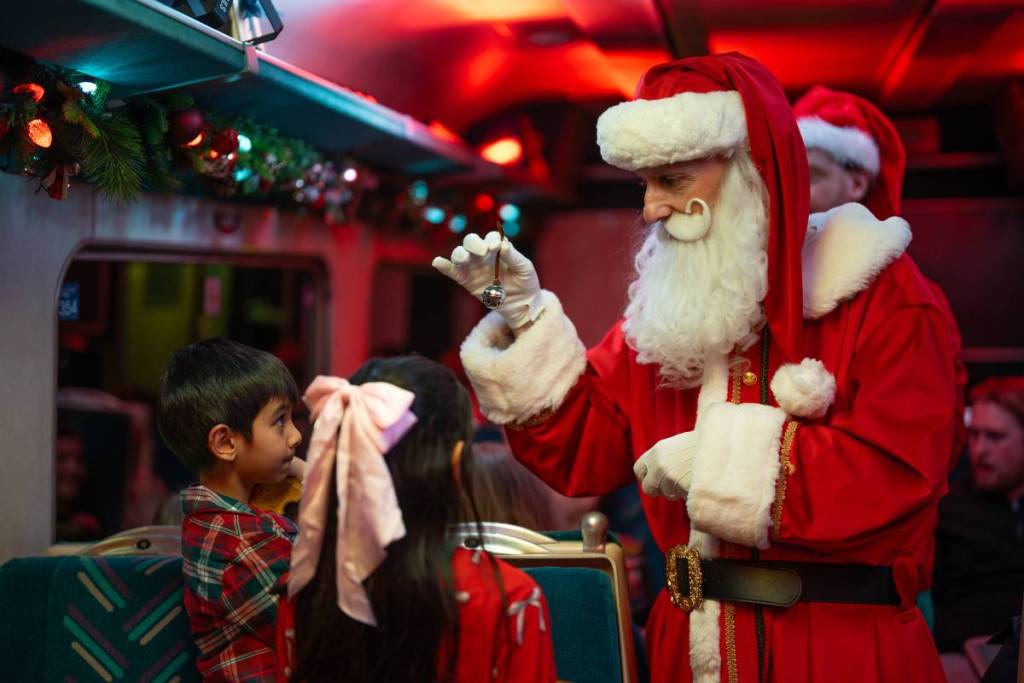 Father Christmas showing the bell to children