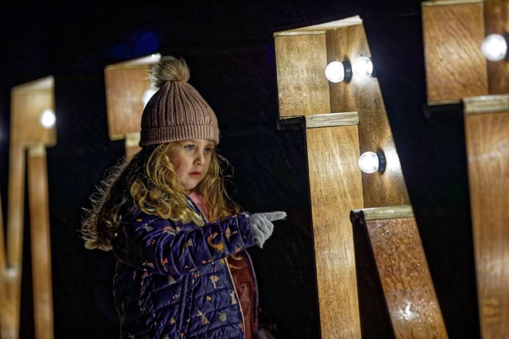 A girl pointing at the Luminate sign