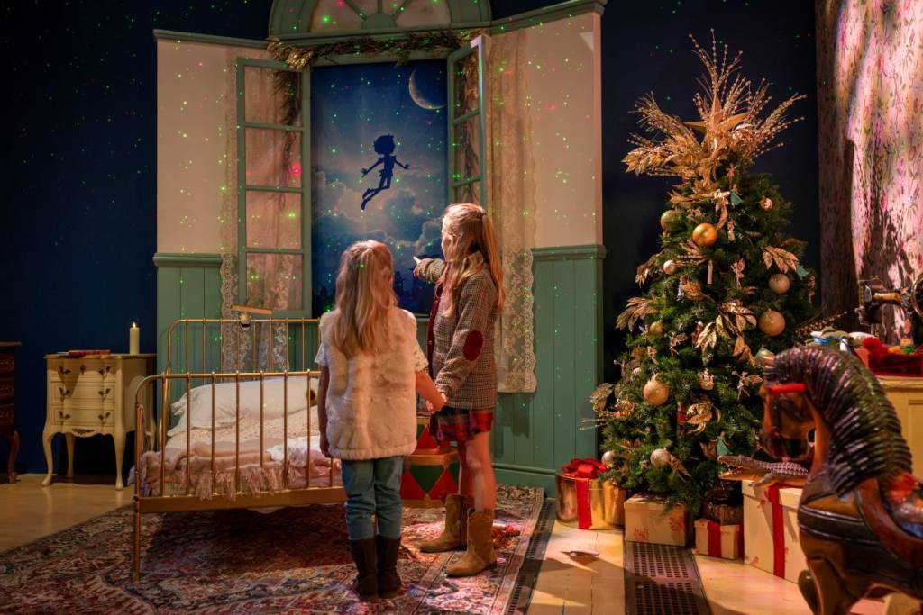 girls pointing at the open door with peter pan decoration 