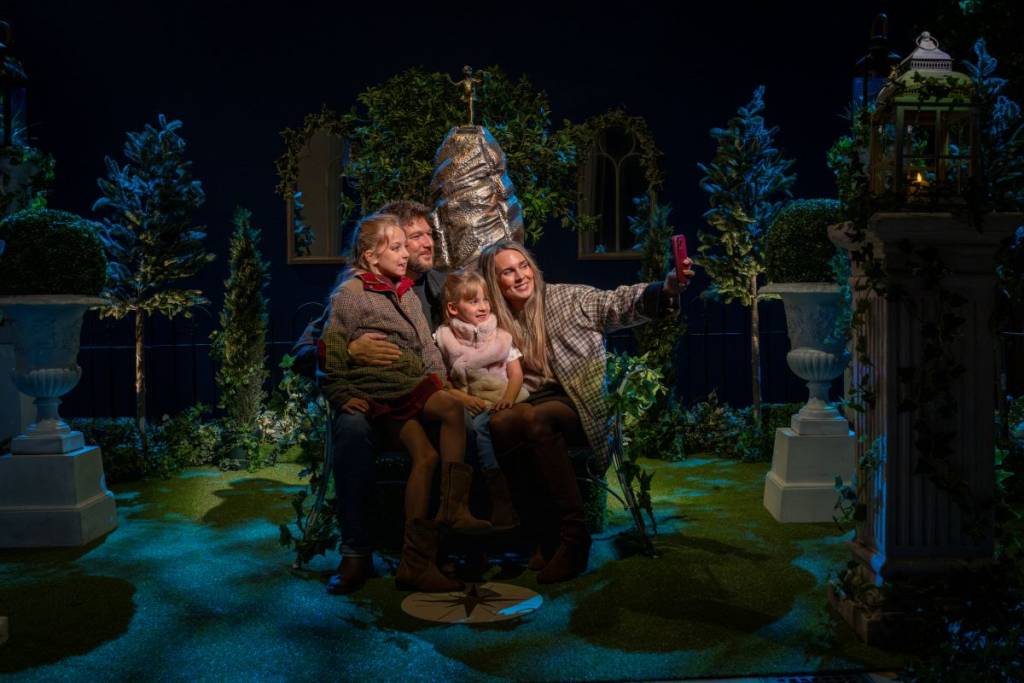 family taking a picture surrounded by garden decorations