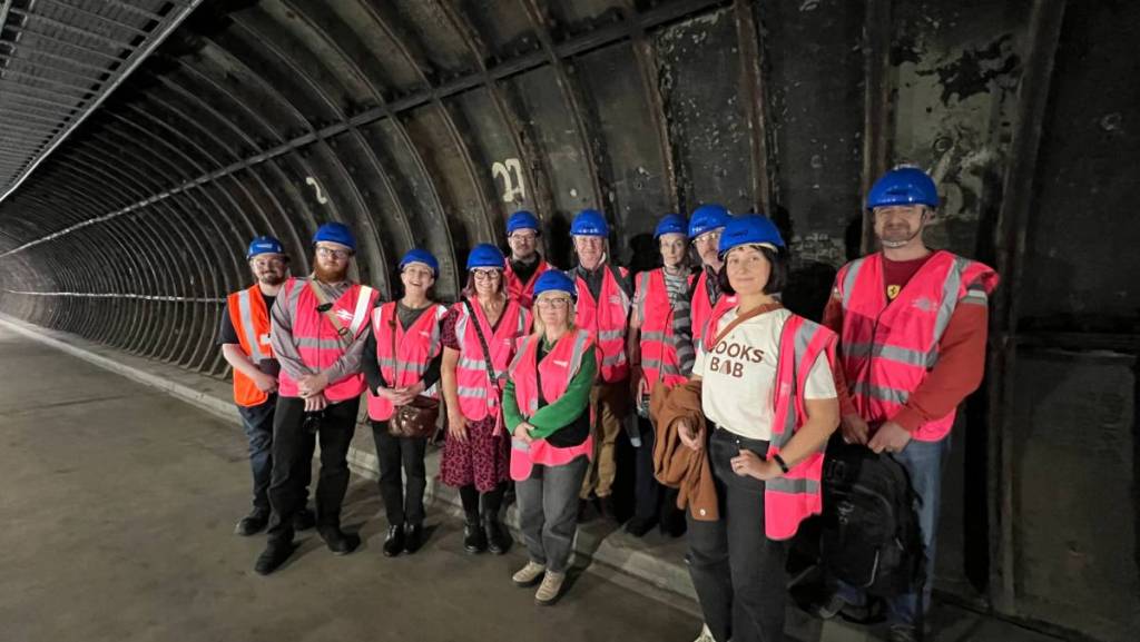 birmingham new street tunnel tour with people wearing pink high vis vests and blue hard hats