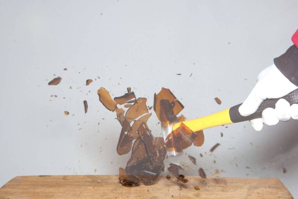 Breaking a glass bottle with a hammer