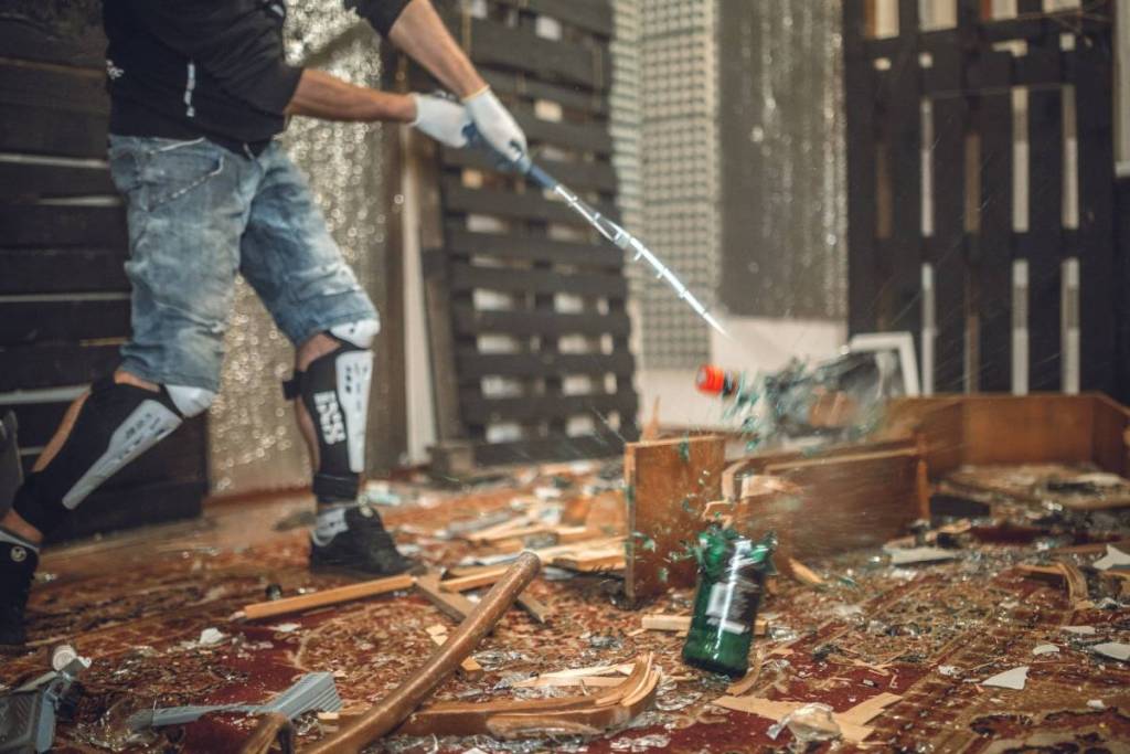 a man smashing the bottle with golf club