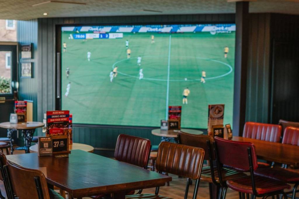 A giant screen showing football at The Bulls Head