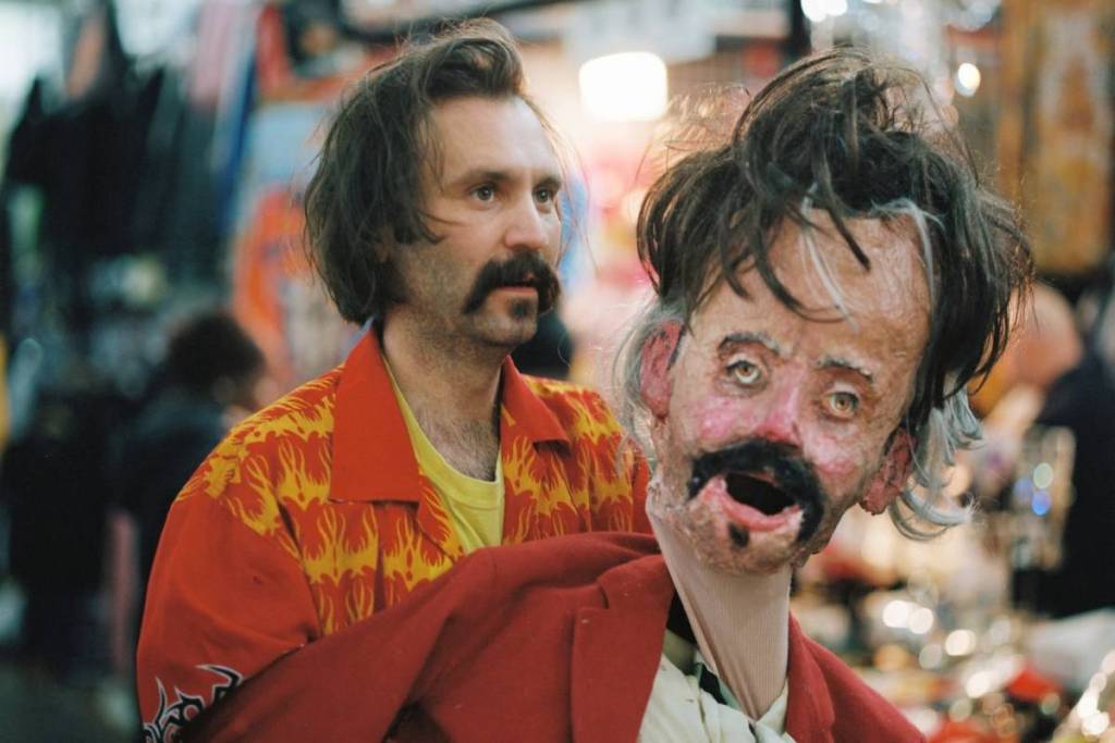 Tat vision with a papier mache version of himself