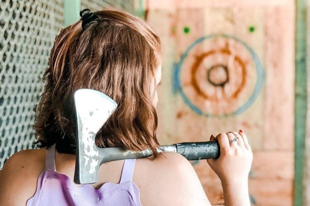 a photo of a woman about to throw an axe
