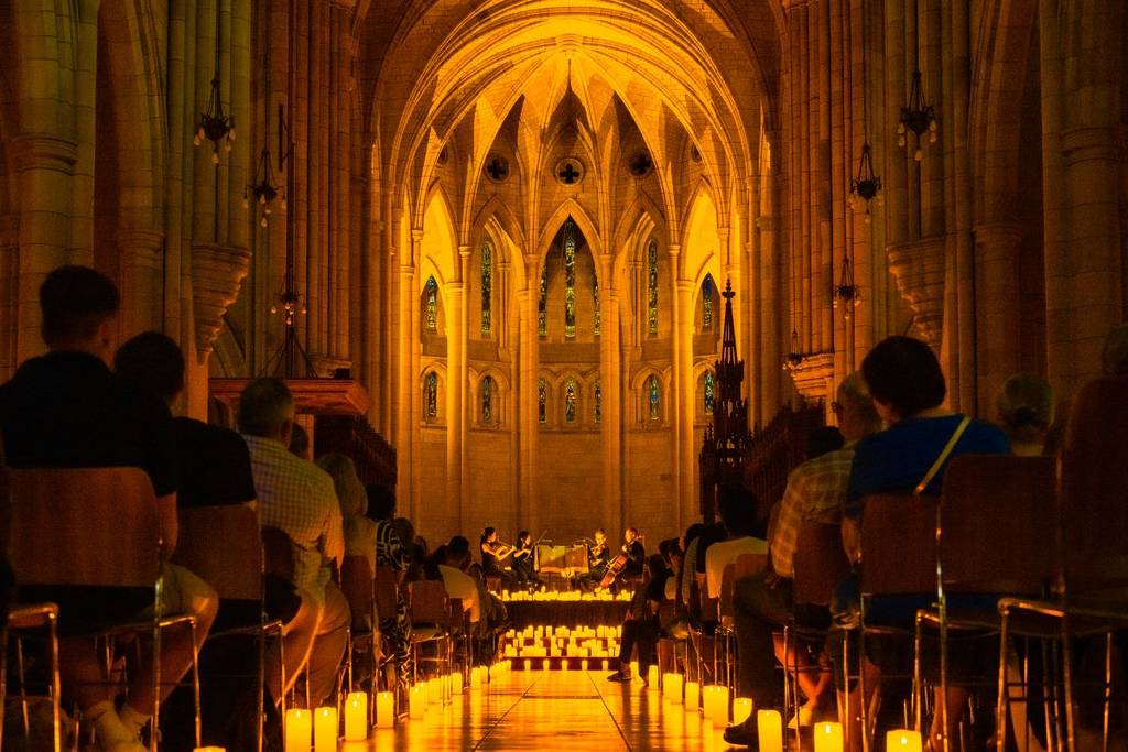 The aisle inside St John's Cathedral illuminated by candles.