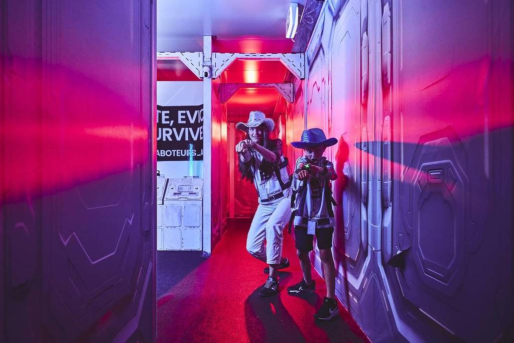 Two boys stop and point guns down a hallway at Saboteurs.