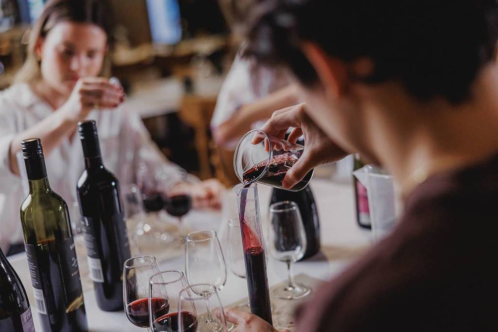 A waiter pours wine from one glass to another at Sirromet Winery.