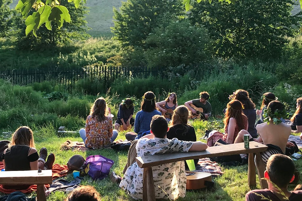 A crowd of people watching a singer in a park