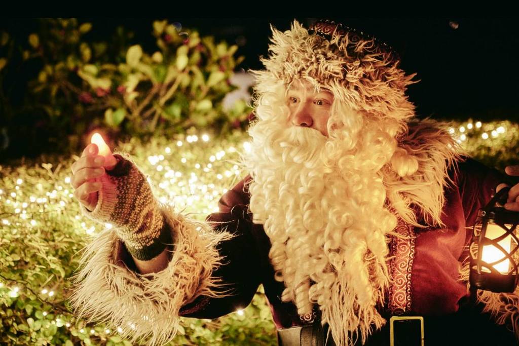 Santa in front of Christmas lights