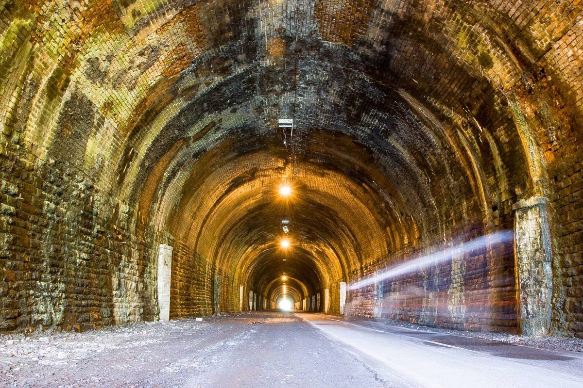 A cyclist riding through the Staple Hill Tunnel on the Bristol and Bath Railway Path.