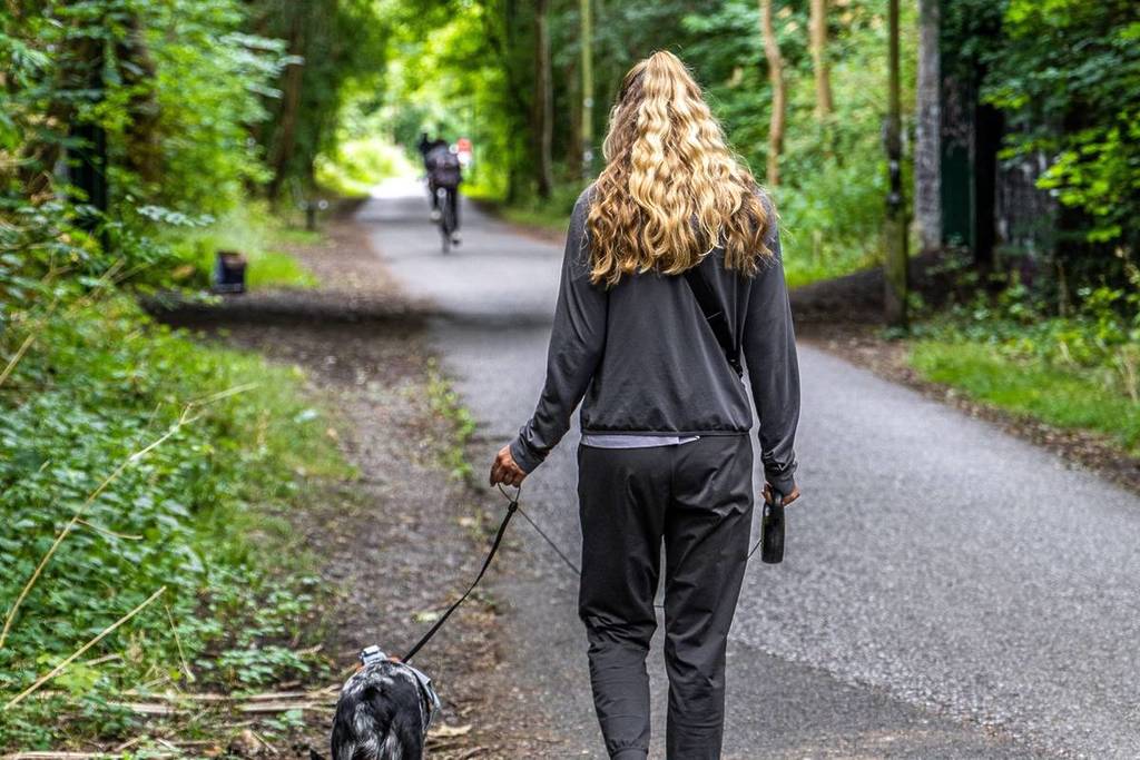 Young women walking a dog on Bristol Course of old railway line now turned into the Bristol to Bath Cycle Path.