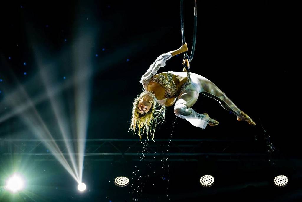 a circus performer is performing on a pole in the air