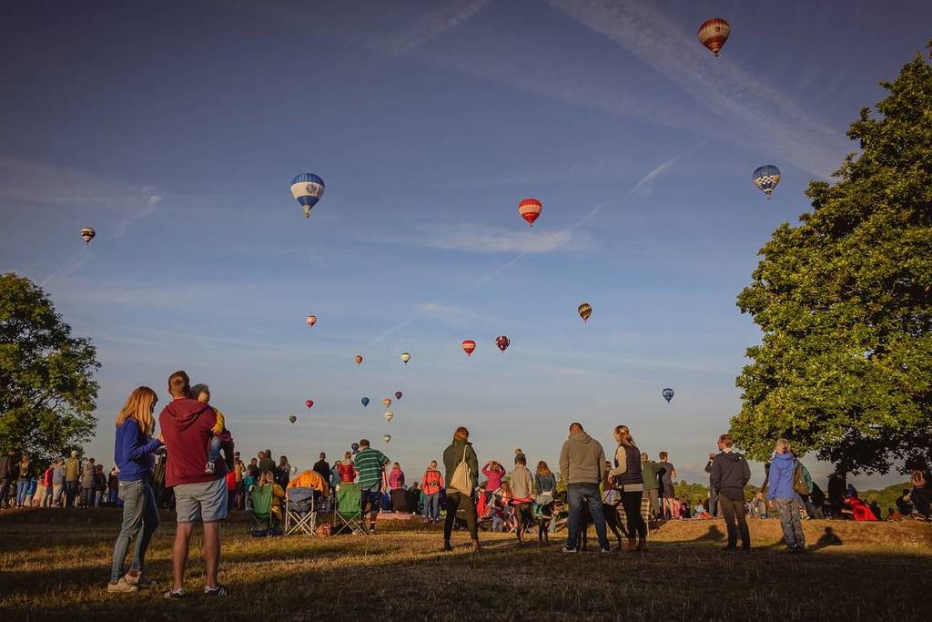 Tourists flock to Bristol UK to witness the 40th Anniversary of the International Balloon Fiesta; hundred of balloons launching at dawn