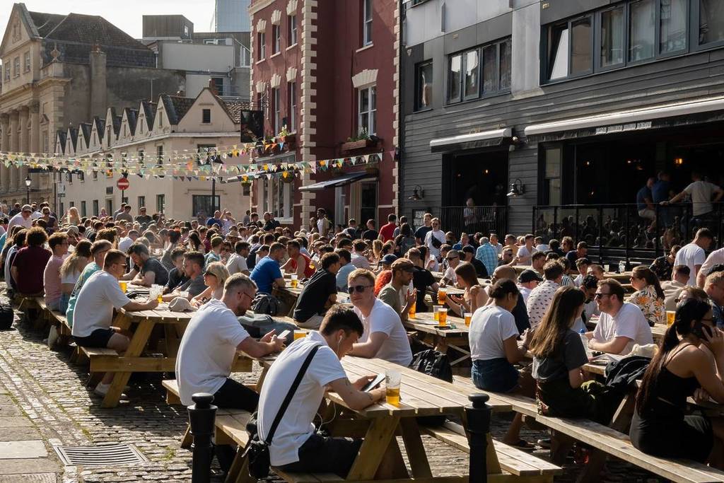 People drinking at outdoor seating on King Street in Bristol City Centre