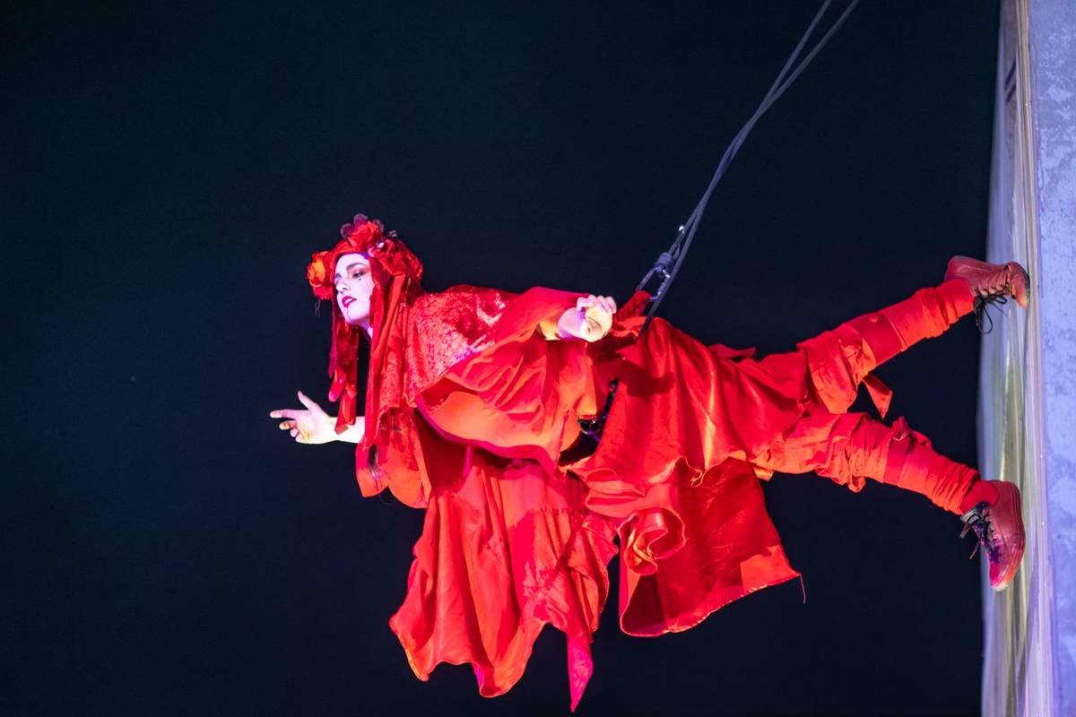 An Invisible Circus performer in red