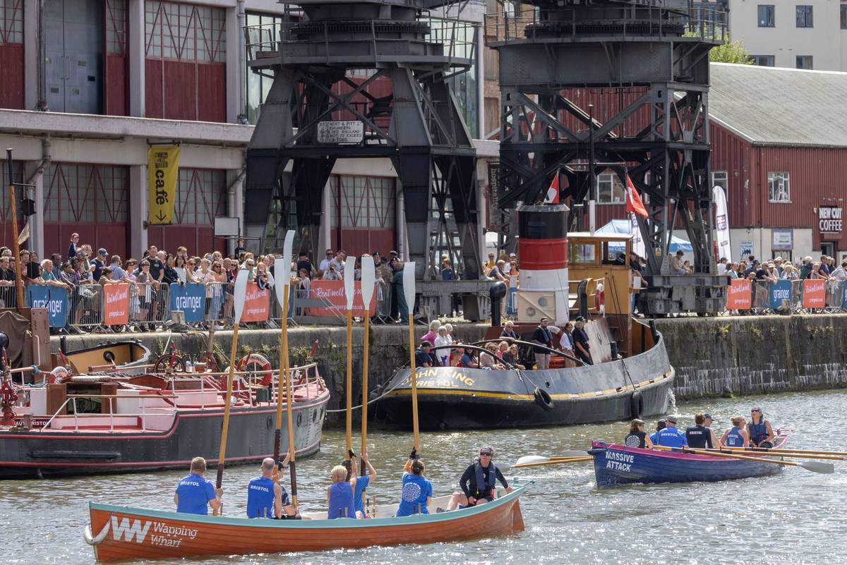 A crowd watching rowers at the harbour in Bristol