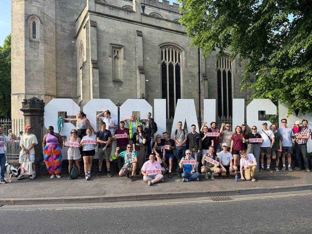 Bristol Transformed stood outside Trinity Centre holding 'Ceasefire Now' banners