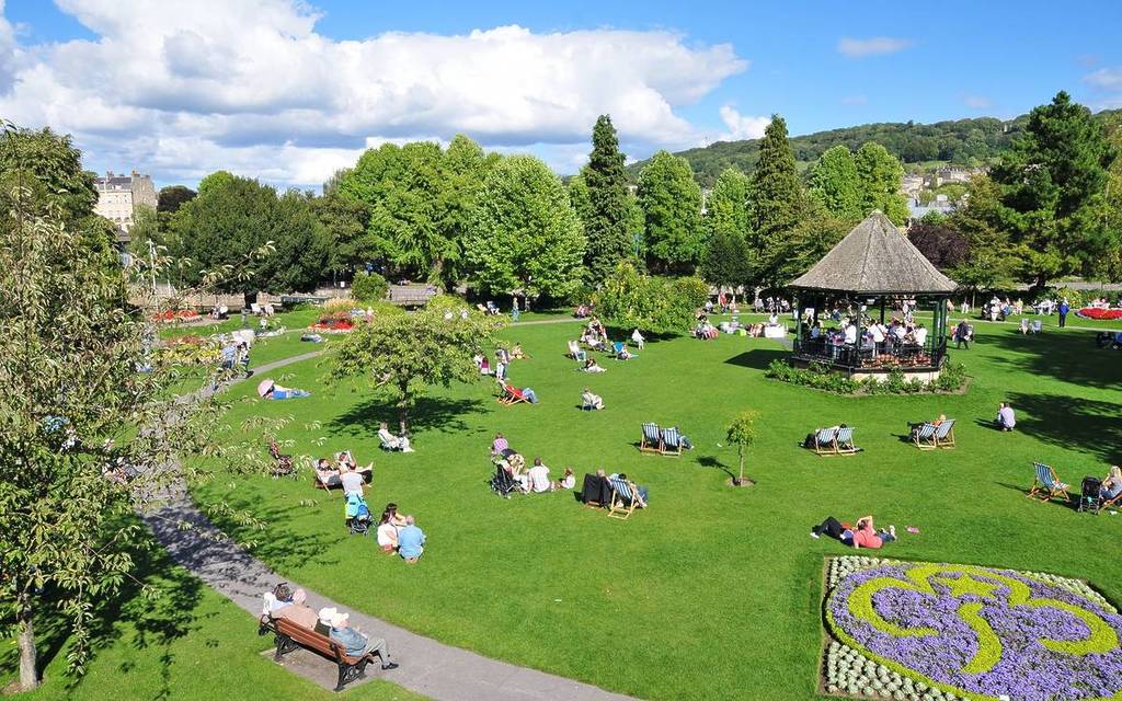 Bath, UK - September 12, 2010: Tourists and locals enjoy a sunny day in Parade Gardens. The Somerset city of Bath has UNESCO World Heritage status and receives over 4 million visitors each year.