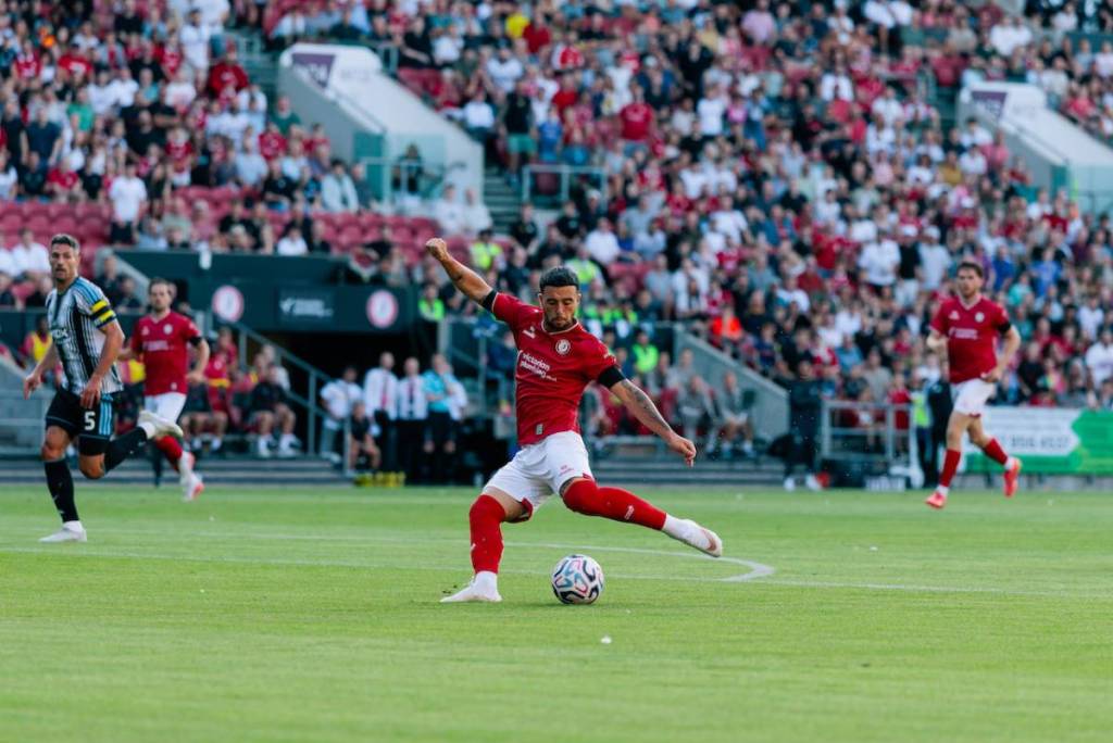 a footballer kicking a football in the field