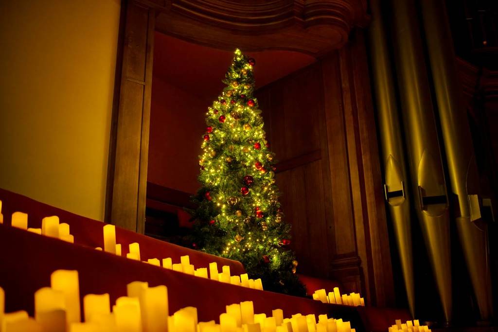 A Christmas tree sitting on top of stairs decorated with thousands of candles