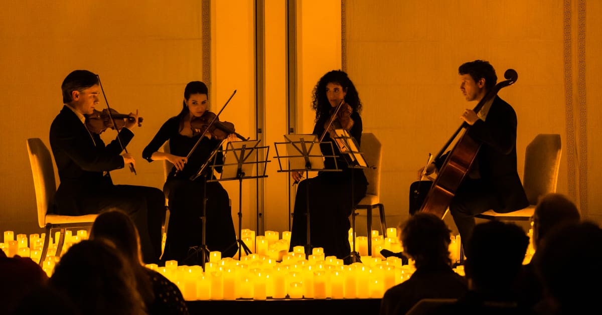 A string quartet performing amid a sea of candles