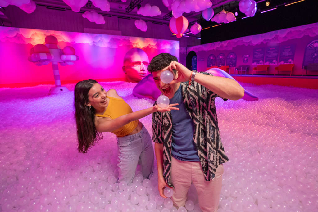 A woman and a man play in a ball pit at Bubble Planet.