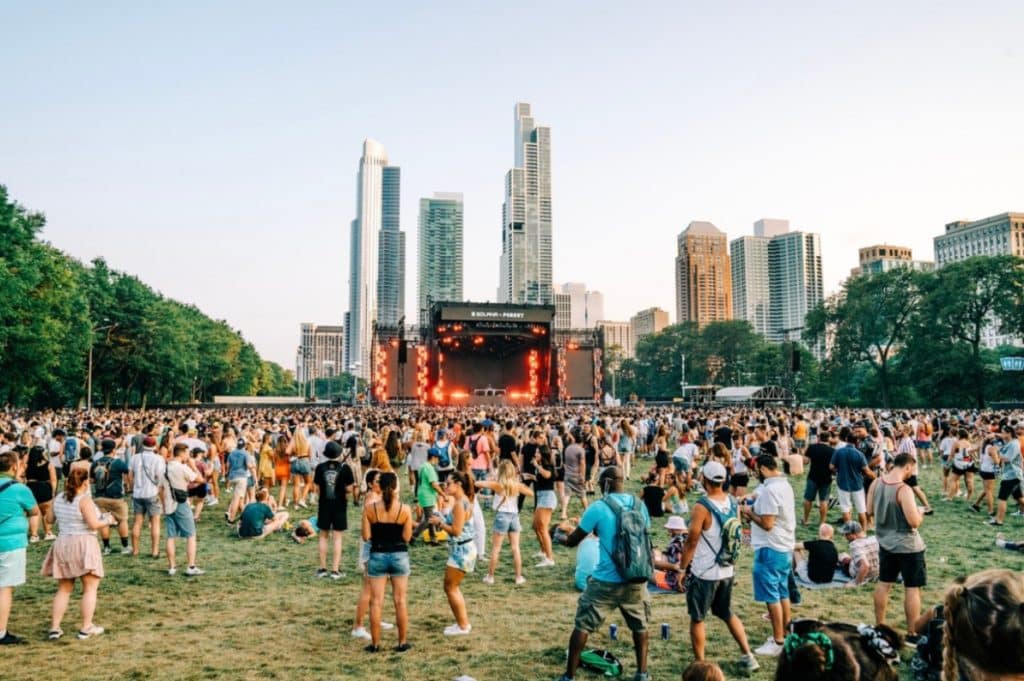 Multitud congregada en torno al escenario principal con los edificios de Chicago al fondo