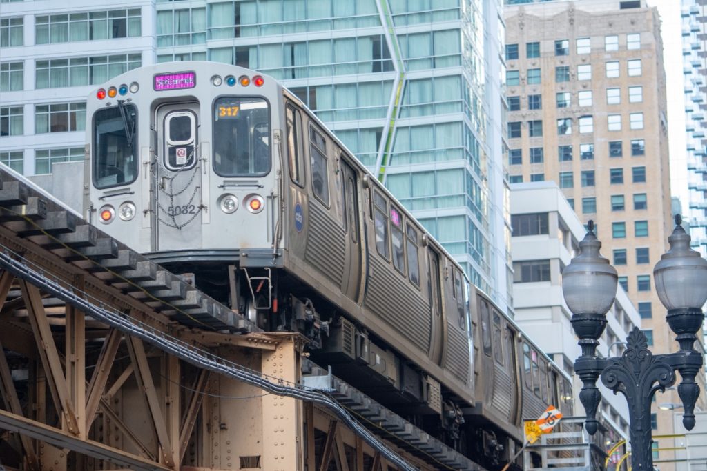 Pink line train pictured on the above ground rail line