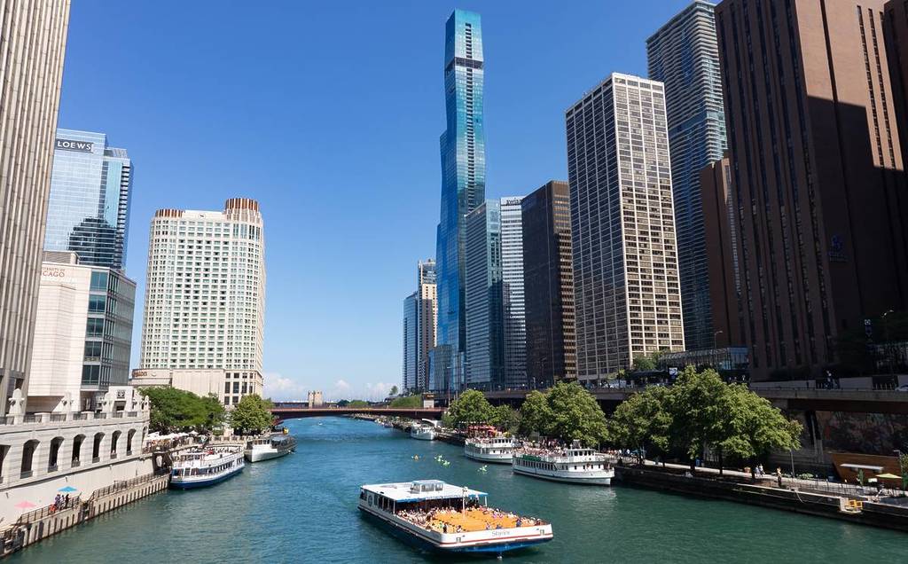The Chicago River in Downtown Chicago with boats and the St. Regis Tower seen in the background