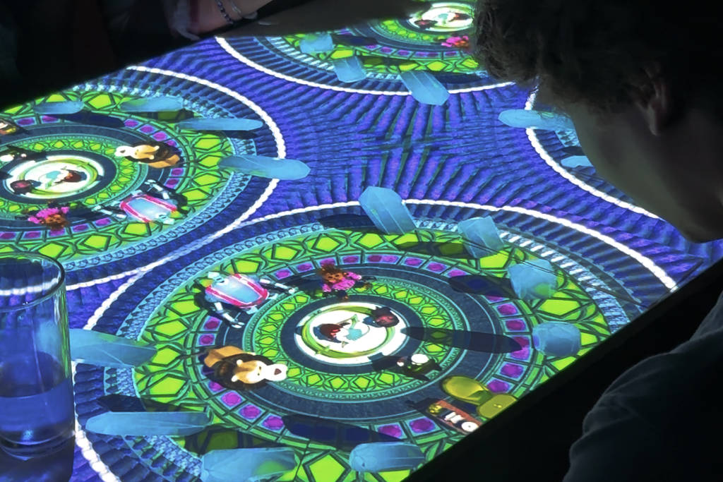 A person looking at their table decorated by a projection inspired by Wizard of Oz at Sensory Feast