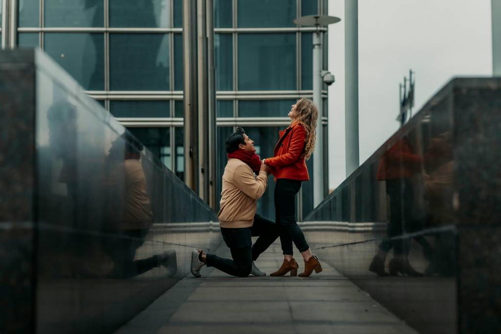 A man proposing to a woman in an urban setting.