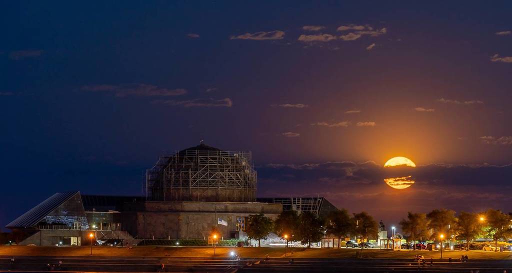 Chicago, Illinois - 26 de mayo de 2021: Luna llena saliendo detrás del Planetario Adler en Chicago