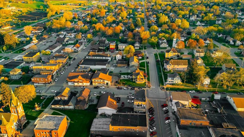 New Glarus Wisconsin at sunset showing city buildings, rooftops, and the Swiss United Church of Christ in golden light.