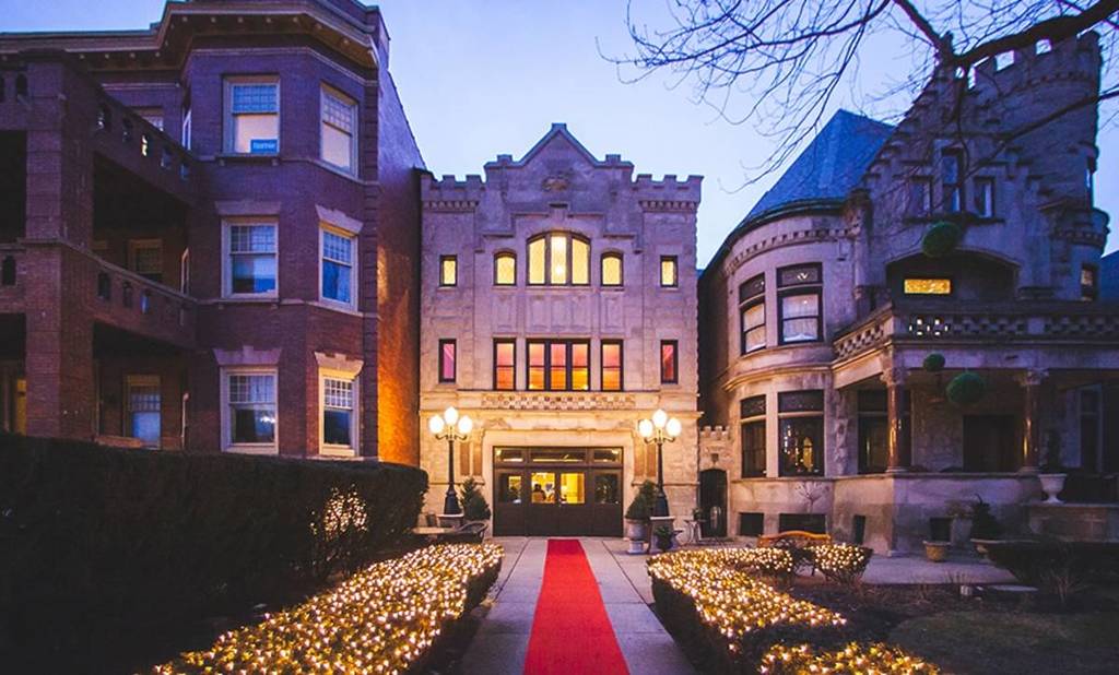 The edifice of Stan Mansion in Chicago with a red carpet, illuminated.