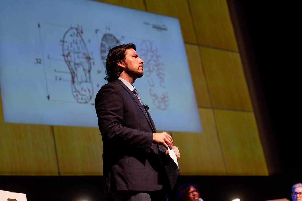 A lawyer points to the evidence on a screen at The Jury Experience.