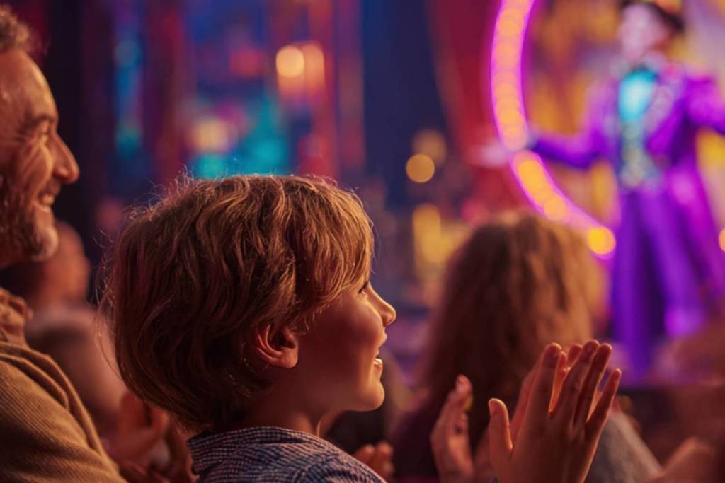A child claps as he watches a magician on stage at The Magic Gateway.
