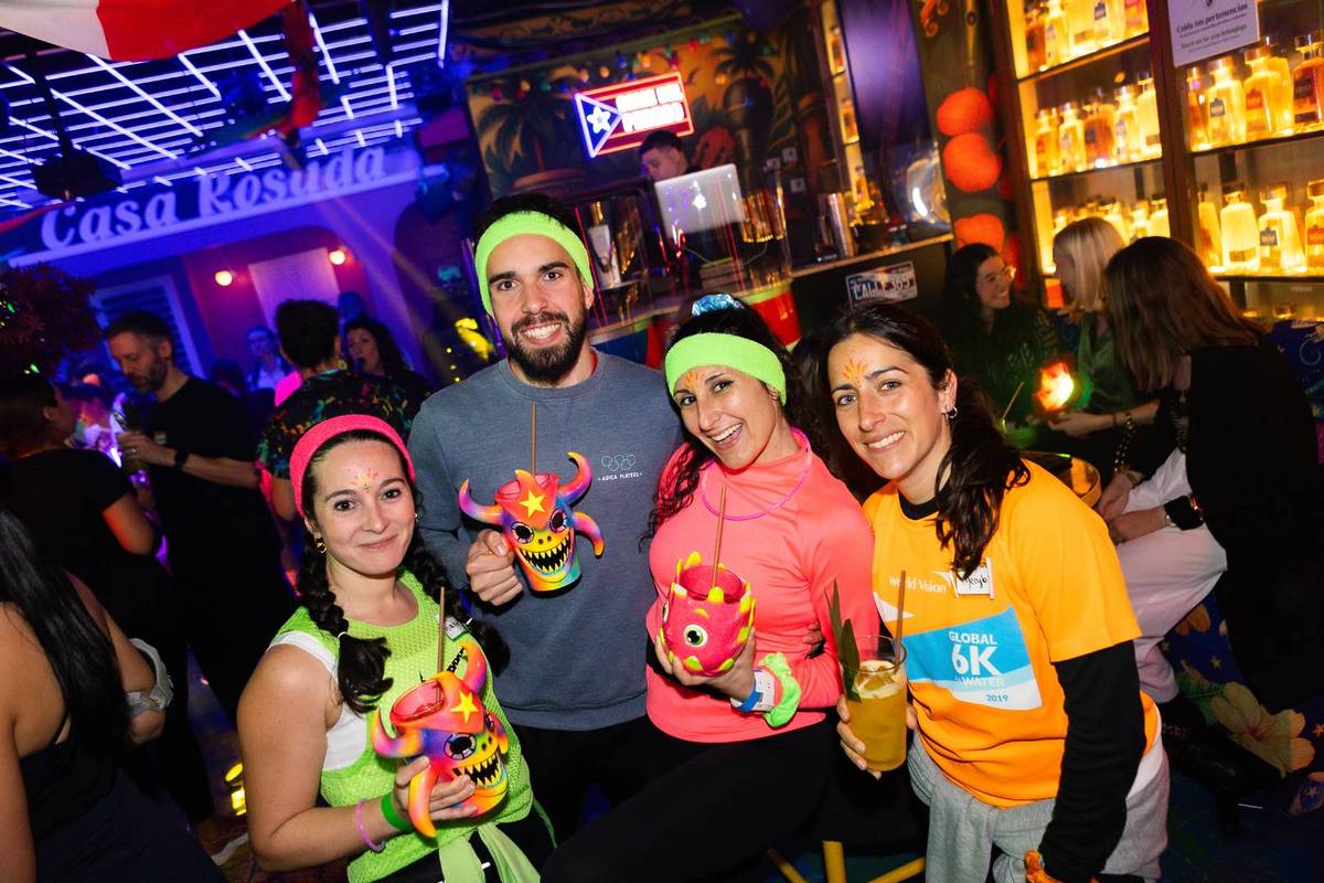 A group of friends together drinking cocktails at Luminous Party Run afterparty