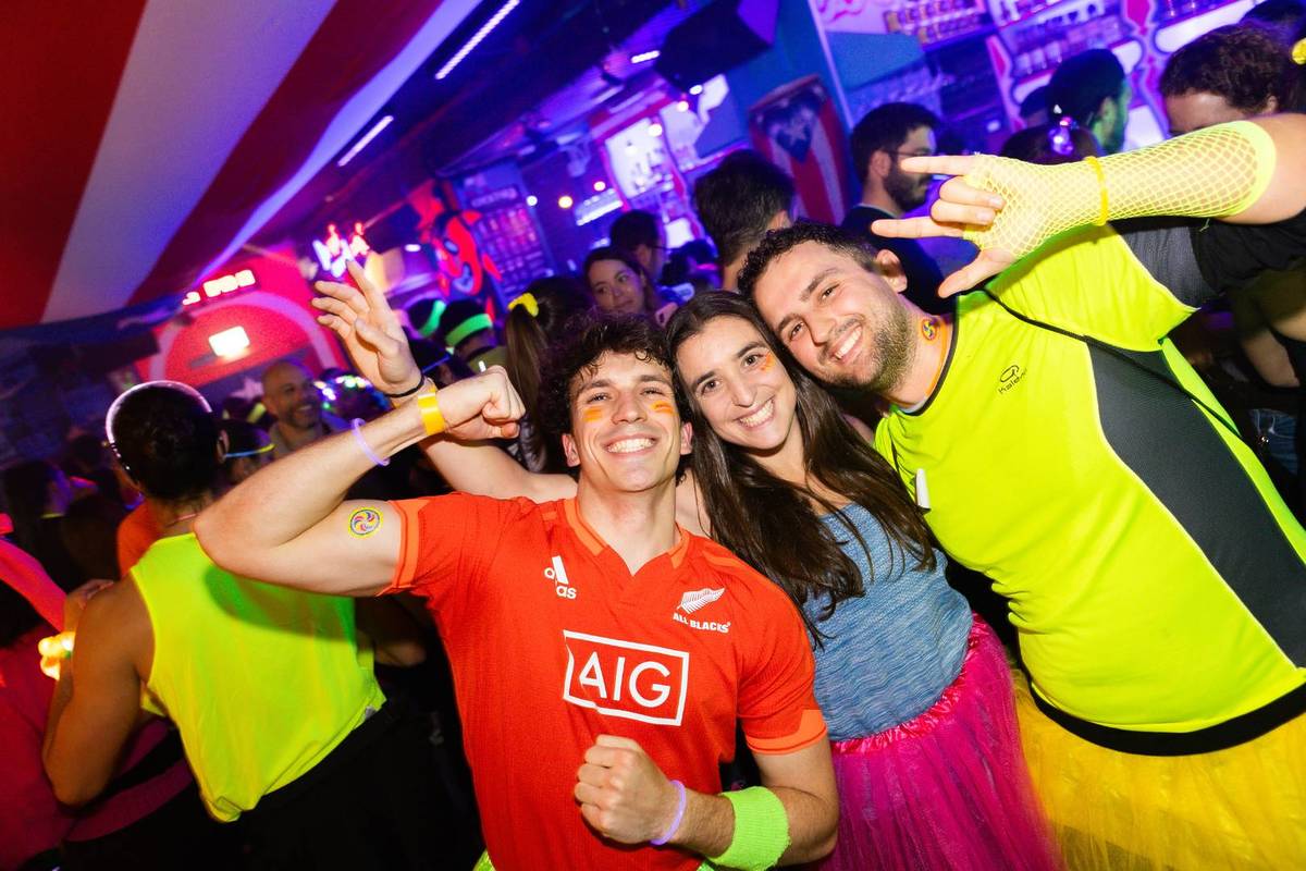 Three friends posing for a photo inside a bar
