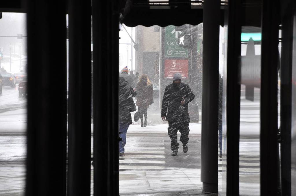 Peatones cruzando la calle durante una tormenta de nieve en Chicago.