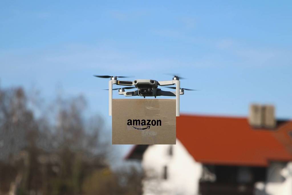 Enfoque electivo en la entrega de paquetes por drones con el logotipo de Amazon en el cartón.