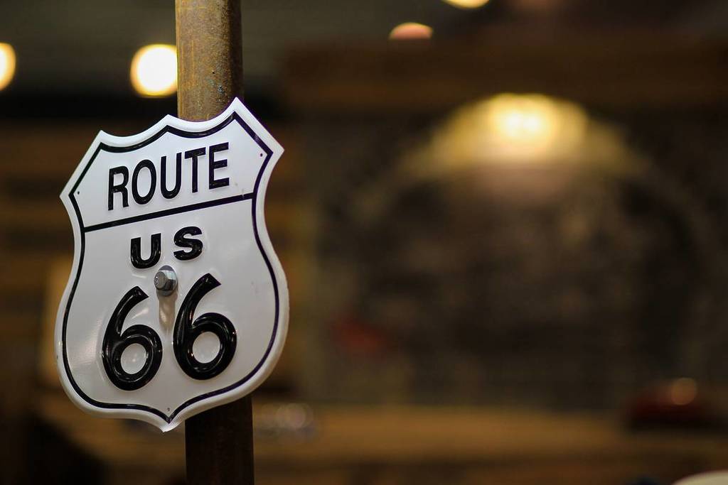 Route 66 road sign. White metal plate of Route 66. Officially US Route 66. City of Seligman, Arizona. Historic Route 66 sign.