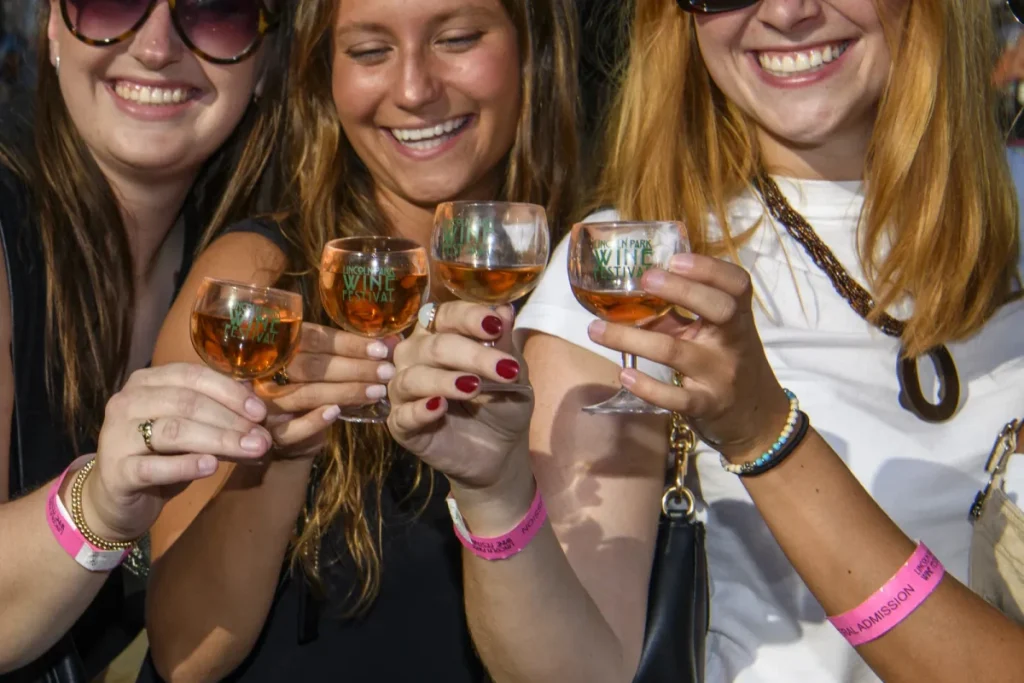 tres personas que sonríen y beben vino