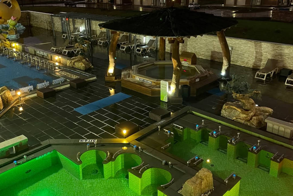 Image shows pools at the Spa Castle Texas facility at night.