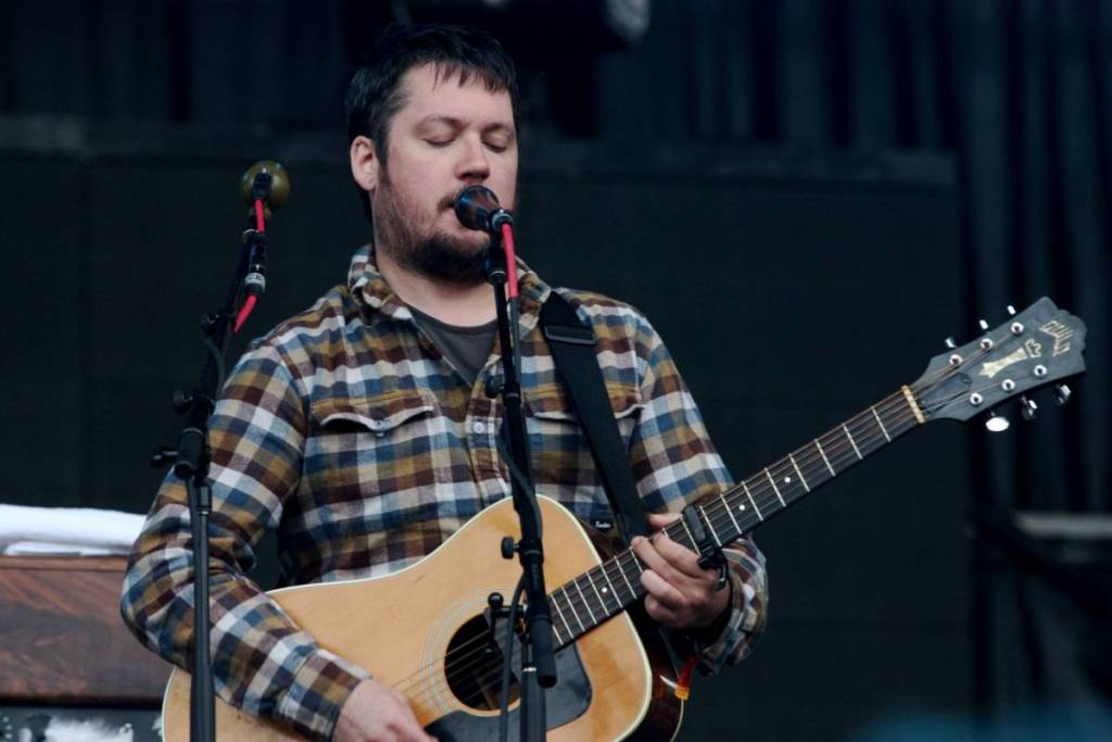 Image shows Isaac Brock of Modest Mouse performing on stage.